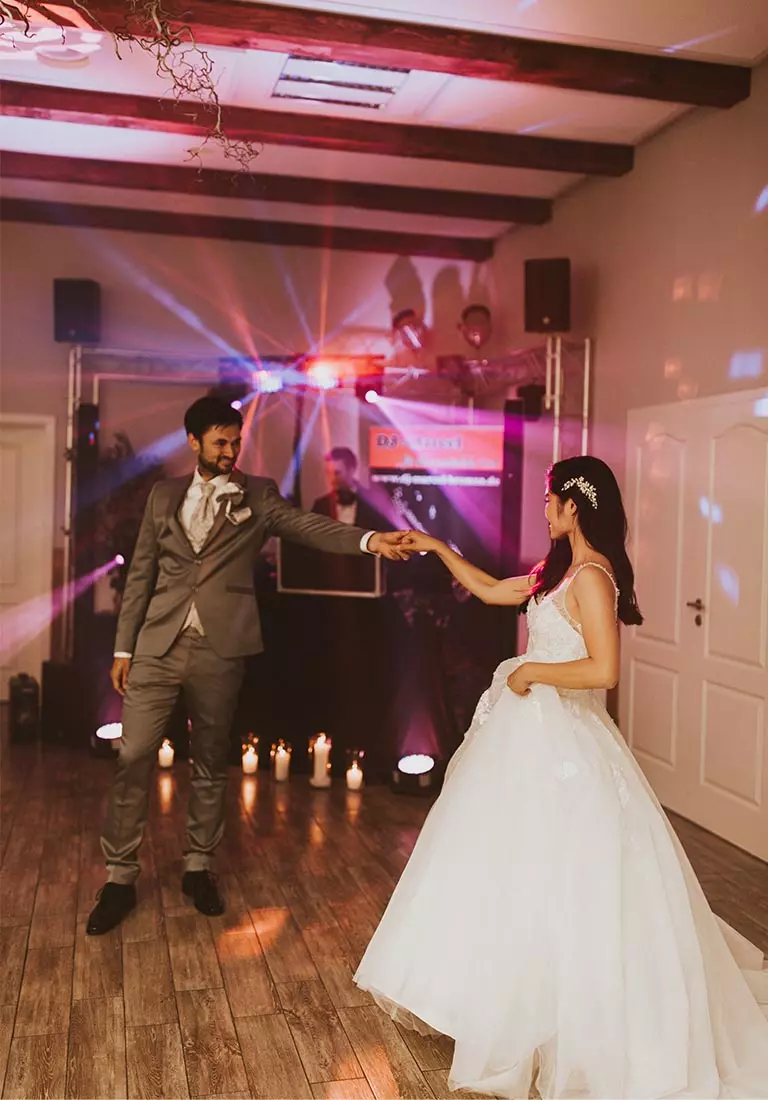 DJ Marcel legt für eine zufriedenes Brautpaar auf. Das Brautpaar tanzt. Marcel legt Musik auf.